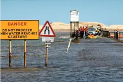  ??  ?? A tide table, pair of compasses and a marine chart used to gauge tides.
Tide tables and signs show crossing times for the tidal road at Lindisfarn­e. Here, emergency services attend a visitor on the causeway. As the water rises, stranded travellers have to climb up into the tower shelter for safety.