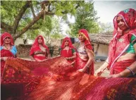  ??  ?? Women weavers from Rajasthan display a rug.