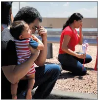  ?? AP/JOHN LOCHER ?? Julio and Danielle Novoa, with their 10-month-old son Richard, kneel Sunday near a makeshift memorial for the victims of Saturday’s shooting in El Paso, Texas.