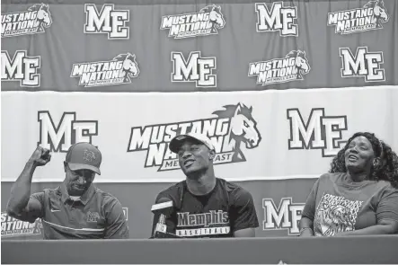  ?? YALONDA M. JAMES/THE COMMERCIAL APPEAL ?? April 11, 2018: East High School point guard Alex Lomax, flanked by his parents Alex Lomax, left, and Kamesha Jefferson, prepares to sign his national letter of intent to attend University of Memphis during an event at Lester Community Center.