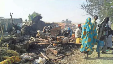  ?? DOCTORS WITHOUT BORDERS VIA AFP/GETTY IMAGES ?? Residents survey the damage Tuesday after a fighter jet accidental­ly bombed a refugee camp in northeast Nigeria.