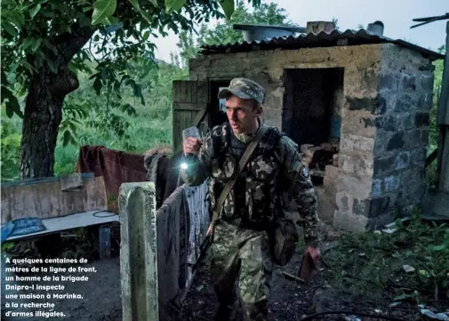  ??  ?? A quelques centaines de mètres de la ligne de front, un homme de la brigade Dnipro-1 inspecte une maison à Marinka, à la recherche d’armes illégales.