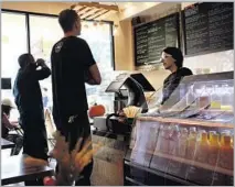  ?? Dania Maxwell Los Angeles Times ?? KIERA MALONEY serves customers at the Punchbowl, the second outlet for the L.A.-based vegan and organic juice bar.