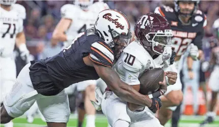  ?? TROY TAORMINA/USA TODAY SPORTS ?? OSU linebacker Nick Martin (4) attempts to tackle Texas A&M quarterbac­k Marcel Reed (10) during the first quarter of the Texas Bowl on Wednesday at NRG Stadium in Houston.