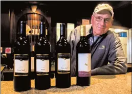  ?? TRIBUNE NEWS SERVICE ?? Heritage Oaks Winery owner Tom Hoffman stands with some of his bottles at the winery in Acampo.