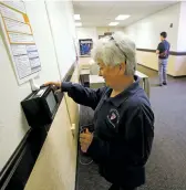  ?? LUIS SÁNCHEZ SATURNO/THE NEW MEXICAN ?? Rita Arellano clocks in last month at City Hall. The city is now using a computer-based timekeepin­g system that forces employees to punch in and punch out, creating a precise and paperless record of hours worked.