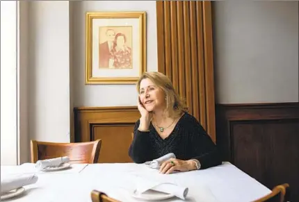  ?? ADRIANA HELDIZ U-T ?? Athens Market Taverna owner Mary Pappas sits at her downtown restaurant with a picture of her parents on the wall behind her.