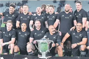  ??  ?? New Zealand’s captain Kieran Read celebrates with team mates as they pose for a photograph with the Bledisloe Cup. — Reuters photo