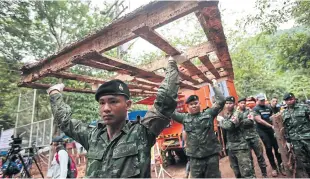  ??  ?? FAR LEFT LEFT Soldiers deliver a large framed structure to be used as support for the evacuation of the trapped boys and their coach.