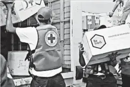  ?? INTERNATIO­NAL COMMITTEE OF THE RED CROSS ?? A video image shows volunteers loading aid into waiting vehicles Tuesday in Venezuela.