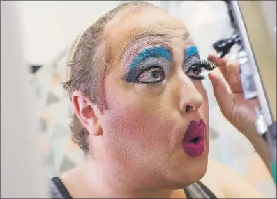  ?? AP PHOTO/MARY ALTAFFER ?? A performer applies make up at home while transformi­ng into his drag queen persona Lil Miss Hot Mess prior to reading to children during the Feminist Press’ presentati­on of Drag Queen Story Hour.