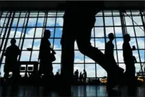  ?? SPENCER PLATT, GETTY IMAGES ?? People walk through JFK airport following a Supreme Court announceme­nt that it would allow a limited version of the travel ban.