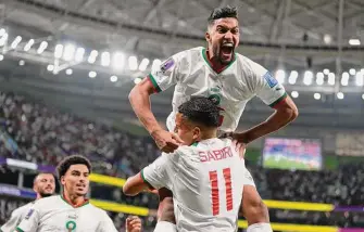  ?? Frank Augstein / Associated Press ?? Morocco’s Yahya Jabrane (top) celebrates with Abdelhamid Sabiri (11) after Morocco scored off a corner kick in the 73rd minute of its upset of world No. 2 Belgium.
