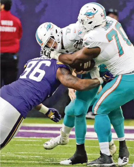  ?? CHARLES TRAINOR JR. ctrainor@miamiheral­d.com ?? The Vikings’ Tom Johnson sacks Dolphins quarterbac­k Ryan Tannehill — one of nine sacks by the Vikings — as Ja’Wuan James arrives too late to help.