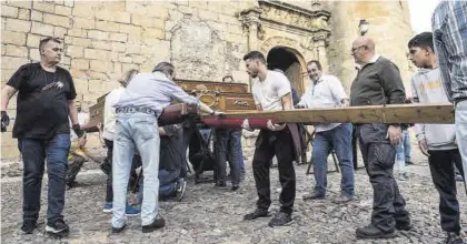  ?? FOTOS: CARLOS GIL ?? Hermanos de la Vera Cruz colaboran en el montaje de los cinco pasos de Jueves Santo, en San Mateo.