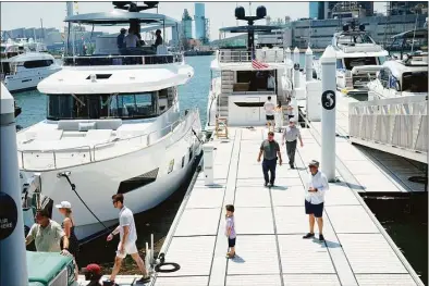  ?? Eddy Martinez / Hearst Connecticu­t Media ?? Visitors look over luxury yachts on display at the Steelpoint­e Yacht and Charter Show in Bridgeport on Friday.