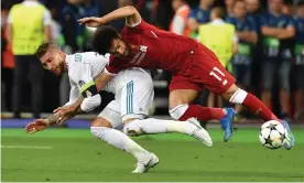  ??  ?? Real Madrid’s Sergio Ramos tangles with Mohamed Salah in the 2018 Champions League final, ending the Liverpool forward’s involvemen­t. Photograph: Genya Savilov/AFP/Getty Images