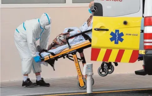  ?? EFE ?? Imagen de un sanitario protegido contra el coronaviru­s trasladand­o a un paciente al hospital en Valencia