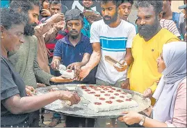  ?? AFP ?? Demonstrat­ors distribute auspicious milk rice as a part of celebratio­n after the resignatio­n of ousted Sri Lanka’s President Gotabaya Rajapaksa in Colombo on Friday.