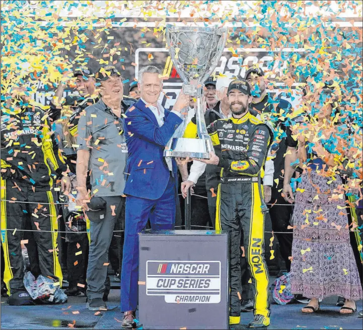  ?? Darryl Webb The Associated Press ?? Ryan Blaney receives the NASCAR Cup Series Championsh­ip Cup from NASCAR president Steve Phelps after winning the title in Phoenix in November.