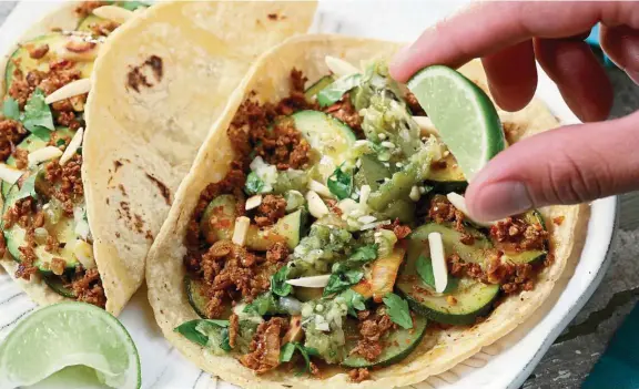  ??  ?? To build that taco, start with filling, then salsa, then finishing toppings, such as the coriander and slivered almonds in this zucchini, chorizo and almond taco. — Photos: Chicago Tribune/ Tribune News Service