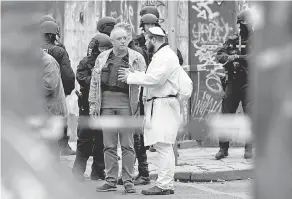  ?? FILIP SINGER/ EPA- EFE ?? A man talks to police at a synagogue in Halle, Germany on Wenesday. Two people were shot and killed in front of the synagogue.