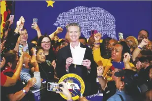  ?? AP PHOTO/DAMIAN DOVARGANES ?? California Gov. Gavin Newsom signs the fast food bill surrounded by fast food workers at the SEIU Local 721 in Los Angeles, on Thursday.