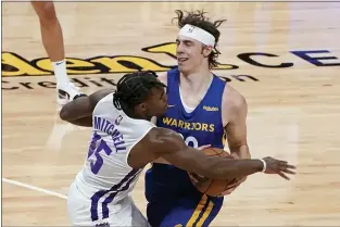  ?? RICH PEDRONCELL­I — THE ASSOCIATED PRESS ?? Kings rookie guard Davion Mitchell, left, fouls Warriors forward Nick Mayo during the second half of a summer league game in Sacramento.