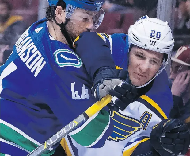  ??  ?? Canucks defenceman Erik Gudbranson, slamming St. Louis Blues winger Alexander Steen into the boards Dec. 20 at Rogers Arena, has continued to struggle in the possession game this season and has been on the ice for seven of the team’s last nine goals against.