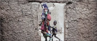  ?? PICTURE: THE WASHINGTON POST BY JANE HAHN ?? A woman walking with her children amid destroyed homes in Banki, Nigeria.