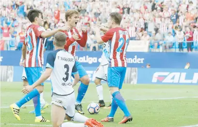  ??  ?? El delantero francés del Atlético de Madrid Antoine Griezmann (al centro) celebra con sus compañeros el gol marcado ante el Deportivo.