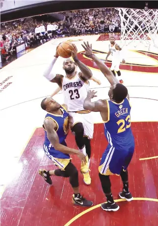  ??  ?? LeBron James (23) of the Cleveland Cavaliers drives to the basket in the first quarter against Andre Iguodala (9) and Draymond Green (23) of the Golden State Warriors in Game 4 of the
2017 NBA Finals at Quicken Loans Arena on Fridat in Cleveland,...