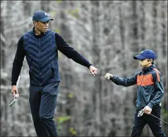  ?? PHELAN M. EBENHACK/AP 2020 ?? Tiger Woods gives his son Charlie a fist bump after Charlie made a putt on the 12th green during a practice round of the Father Son Challenge golf tournament in Orlando, Fla., last year. The two will pair up again next week in the PNC Championsh­ip.