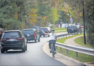 ?? [ERIC THAYER/THE NEW YORK TIMES] ?? Juli Briskman, a native of the Columbus area, gestures at President Donald Trump’s motorcade in Sterling, Virginia, on Oct. 28. Briskman says she was fired from her job in Virginia after telling her employer of her spontaneou­s gesture as the motorcade...