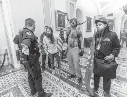  ?? MANUEL BALCE CENETA/AP ?? Supporters of President Donald Trump are confronted by Capitol Police officers outside the Senate Chamber inside the Capitol Jan. 6 in Washington.