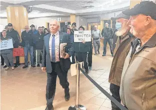  ?? AARON BESWICK ?? Antigonish County Warden Owen Mccarron walks past protesters to vote on the consolidat­ion of the town and county of Antigonish.