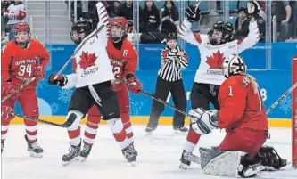  ?? NATHAN DENETTE THE CANADIAN PRESS ?? Canada players celebrate a goal against Olympic Athlete from Russia goaltender Valeria Tarakanova in third-period women’s hockey action Monday.