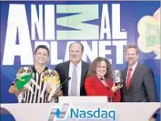  ?? Rob Kim Getty Images ?? AN ANIMAL Planet producer joins Discovery Communicat­ions executives at Nasdaq in New York in ’16.