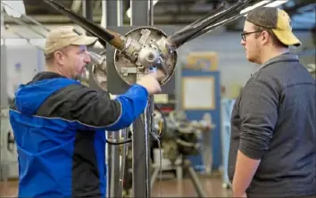  ?? Pam Panchak/Post-Gazette ?? Brian Forsyth, left, of Bethel Park, a 1988 graduate of the Pittsburgh Institute of Aeronautic­s, talks with his son, Nick, 22, talk about propeller maintenanc­e while touring the school during its open house Saturday at the Allegheny County Airport in West Mifflin. Nick Forsyth is looking into the aviation maintenanc­e technician program at the school.