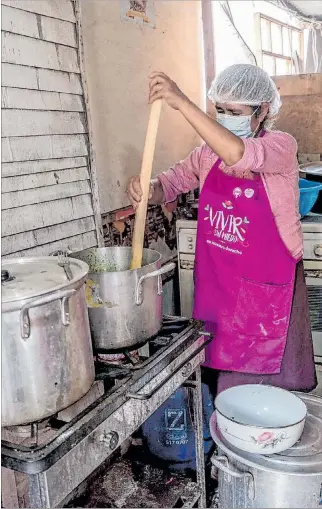  ?? EL PAÍS ?? Crisis. Una mujer en la asociación de vivienda Paraíso, en el norte de Lima, cocina como parte de olla común.