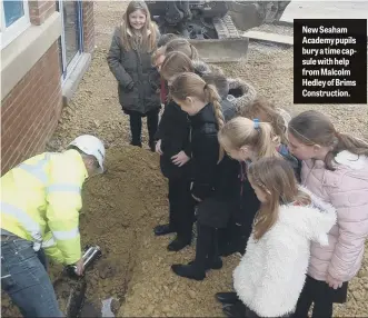  ??  ?? New Seaham Academy pupils bury a time capsule with help from Malcolm Hedley of Brims Constructi­on.