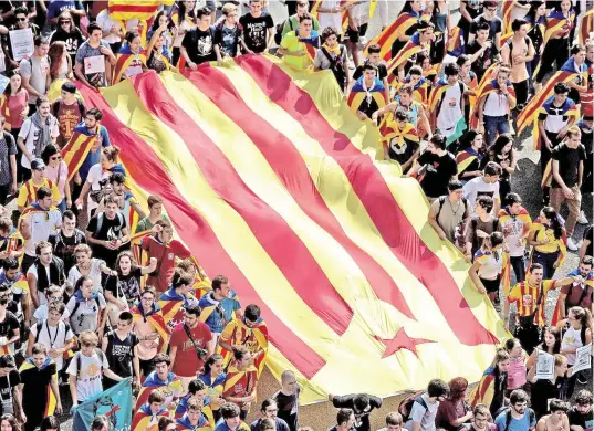  ?? PHOTO AFP ?? Des étudiants universita­ires de Barcelone ont montré leurs couleurs hier en se drapant du drapeau catalan.