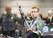  ?? Jessica Hill / Associated Press file photo ?? Detective Barbara J. Mattson, of the Connecticu­t State Police, holds up a Bushmaster AR15 rifle, the same gun used by the Sandy Hook School shooter.