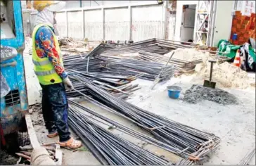  ?? HENG CHIVOAN ?? A worker stands near a pile of rebars at a constructi­on site in the capital’s Chamkarmon district early this month.
