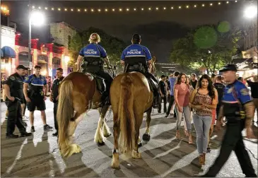  ?? JAY JANNER / AMERICAN-STATESMAN ?? Austin police on horses patrol Sixth Street on what would be a peaceful Friday in early June.