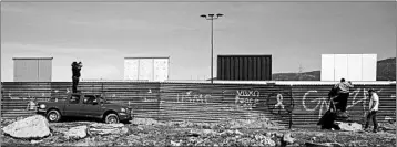  ?? GUILLERMO ARIAS/GETTY-AFP ?? Journalist­s get a glimpse from the Mexican side of the U.S.-Mexico border in Tijuana, across from border-wall prototypes.