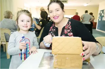  ??  ?? Addison Burton was excited to create a gingerbrea­d house for Christmas with the help of her mum Melissa.