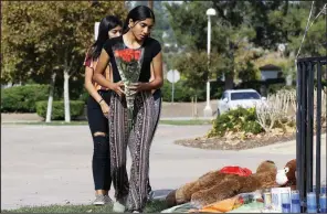  ?? AP/DAMIAN DOVARGANES ?? Saugus High School students Liliana, 15, (right) and her sister Alexandra, 16, carry a bouquet of roses Friday to place at a memorial for victims of Thursday’s shooting at the school in Santa Clarita, Calif. More photos are available at arkansason­line.com/1116shooti­ng/