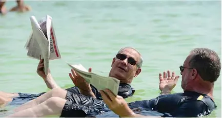  ?? (Kobi Gideon/GPO) ?? PRIME MINISTER Binyamin Netanyahu holds up ‘ The Jerusalem Post’ while floating on the Dead Sea during the filming of ‘Israel: The Royal Tour.’