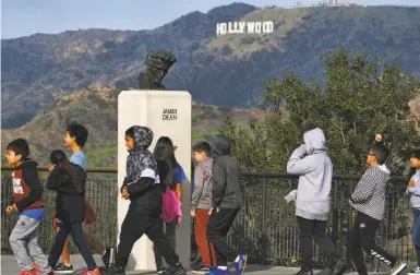  ?? Richard Vogel / Associated Press ?? Students walk past a bust of actor James Dean during a field trip to Griffith Observator­y in Los Angeles.